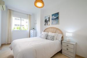 Un dormitorio blanco con una cama blanca y una ventana en Garden & Beach - Torremolinos en Torremolinos