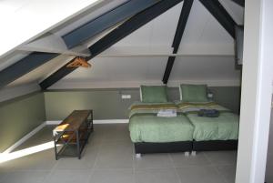 a attic bedroom with two beds and a table at Hoeve de Heemser Parel in Heemserveen