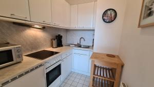 a kitchen with white appliances and a clock on the wall at TopDomizil Apartments Berlin Mitte in Berlin