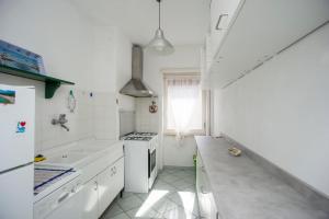 a white kitchen with white appliances and a window at Casa Malu in Marina di Campo