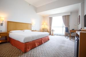 a hotel room with a bed and a desk at The Linden Suites in Manila