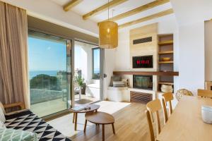 sala de estar con mesa de comedor y chimenea en Villa Theano, en Triopetra