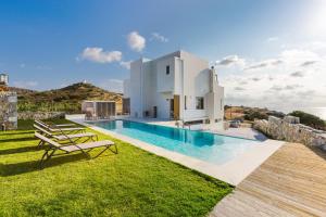 a villa with a swimming pool and a house at Villa Theano in Triopetra
