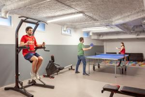 eine Gruppe von Leuten, die in einem Fitnessstudio Tischtennis spielen in der Unterkunft Résidence Kley in Marseille