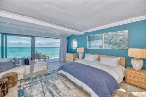 a bedroom with a large bed and a view of the ocean at Marlin Manor in Struisbaai