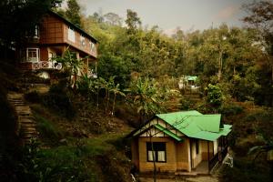 una casa con un paraguas verde en una colina en Kalimpong Village Retreat, en Kalimpong