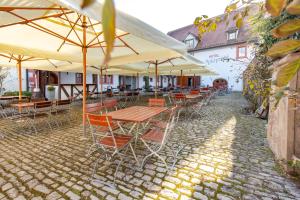 a group of tables and chairs with umbrellas at Hotel Meisnerhof in Erlabrunn