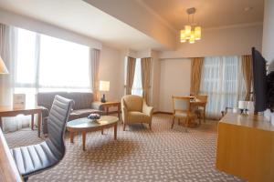 a large hotel room with a living room at The Linden Suites in Manila