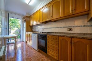 uma cozinha com armários de madeira e um fogão em HomeHolidaysRentals Charme - Costa Barcelona em Santa Susanna
