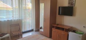 a room with a room with a television and a window at Vila Raduinea in Eforie Nord