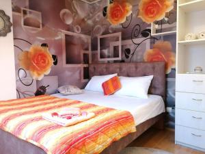 una camera da letto con un letto con fiori sul muro di Apartman Slavica a Nova Varoš