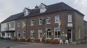 a large brick building with tables and chairs in front of it at Hotel-Cafe Knoors-Meeks Stein Urmond in Berg