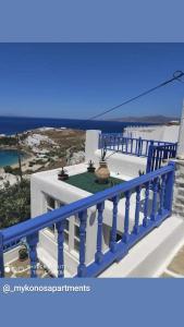 uma varanda com um corrimão azul num edifício em Mykonos Rooms em Agios Stefanos