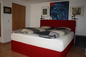 un grande letto con testiera rossa in una stanza di Apartment Seascape - Self Check-In a Duisburg