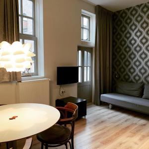 a living room with a table and a couch at Stadslogement By Peek in Sneek