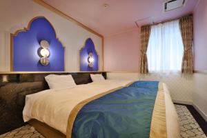 a bedroom with a large bed with purple walls at Four Stories Hotel Maihama Tokyo Bay in Urayasu