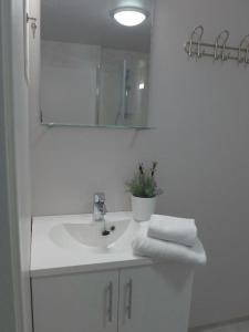 a white bathroom with a sink and a mirror at Lilland Hostel Tau in Tau