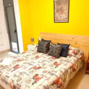 1 dormitorio con 1 cama grande y pared amarilla en Apartamento en el centro, en Reus
