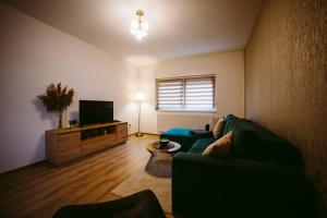 een woonkamer met een bank en een flatscreen-tv bij Apartman Gold in Slavonski Brod