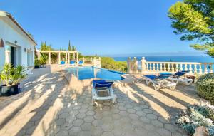 a patio with a pool and chairs and the ocean at La Galesa in Jávea