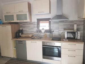 a kitchen with a stove and a microwave at Apartman DIVA in Otočac
