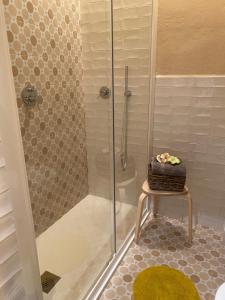 a bathroom with a shower and a stool with a basket at Via Roma 181 in Polignano a Mare