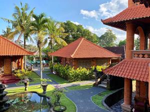 a house with a pond in the middle of a yard at Gayatri in Ubud