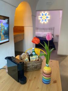 un tavolo con un cesto e un vaso con fiori di Via Roma 181 a Polignano a Mare
