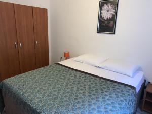 a bedroom with a bed and a picture on the wall at Apartments Epidaurus in Cavtat