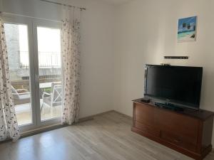 a living room with a flat screen tv next to a window at Apartments Epidaurus in Cavtat