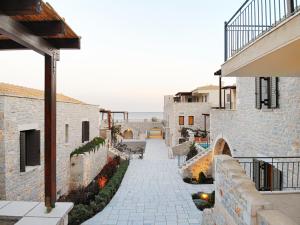 a stone walkway between two buildings with a patio at Margo Beach Hotel in Gythio