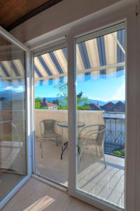 a screened in porch with sliding glass doors with a table at Apartments Pean in Tivat