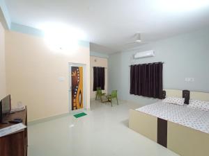 a room with two beds and a tv in it at Zara Homestay Santiniketan in Shānti Niketan