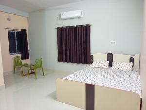 a bedroom with a bed and a table and chairs at Zara Homestay Santiniketan in Shānti Niketan