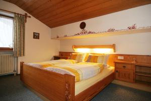 Un dormitorio con una gran cama de madera con luces. en Gästehaus Hanauerbichl en Schönau am Königssee