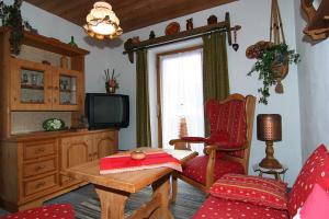 sala de estar con TV, silla y mesa en Gästehaus Hanauerbichl en Schönau am Königssee