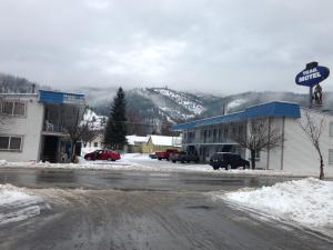 eine schneebedeckte Straße in einer Stadt mit Motel in der Unterkunft Trail Motel in Kellogg