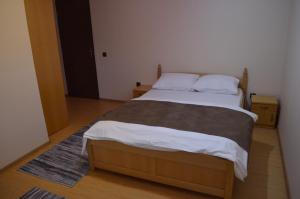 a bed in a room with a wooden floor at Transilvania Garden House in Miercurea-Ciuc