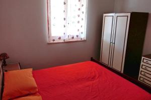 a bedroom with a red bed and a window at Villa Eulalia in Capo Vaticano +25 photos
