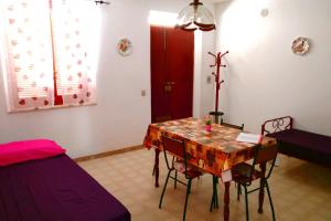 a living room with a table and chairs and a couch at Villa Eulalia in Capo Vaticano
