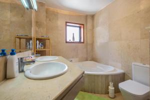 a bathroom with a sink and a tub and a toilet at Casa Tatiana in Acantilado de los Gigantes +17 photos