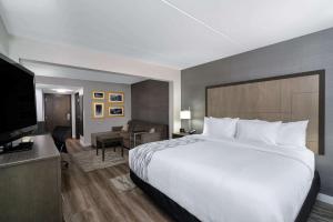 ein Hotelzimmer mit einem großen Bett und einem TV in der Unterkunft La Quinta by Wyndham Raleigh Downtown North in Raleigh