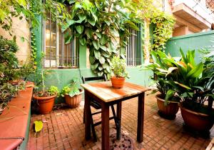a patio with a wooden table and potted plants at Estudio Finestrelles in Barcelona