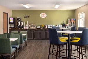 a waiting room with tables and chairs in a restaurant at Super 8 by Wyndham Sioux Falls in Sioux Falls