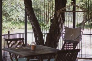 a table and chairs sitting next to a tree at Hello Kruger Hideaway Cottage & Skilpad Studio in Marloth Park