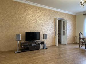 uma sala de estar com uma televisão de ecrã plano e colunas em Cozy Apartment With The Best Patio and Swimming pool em Yerevan