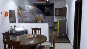 a kitchen with a table and a kitchen with a refrigerator at Vamoose Mudra Midtown in Kalasa