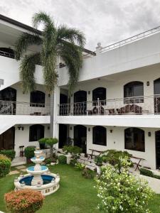 a large white building with a fountain in the yard at Ettamogah Hotel Inc. in Malino