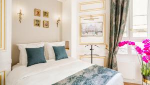 a bedroom with a white bed with blue pillows at Luxury 2 bedroom Apartment - Eiffel Tower in Paris