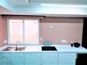 une cuisine avec un évier et une fenêtre dans l'établissement COLLECTION CITY - Bed & Breakfast, Alicante Center I Cocina & Amplia Terraza - Jardín, à Alicante